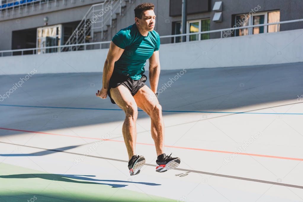 Athlète en plein saut en longueur dans un stade