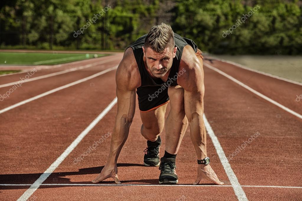 Sprinters dans les starting-blocks sur une piste d’athlétisme